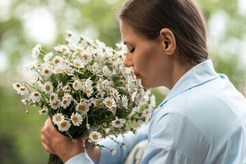 Daisies Bouquet Woman: Person sniffs chamomile flowers outside to appreciate nature, peaceful...
