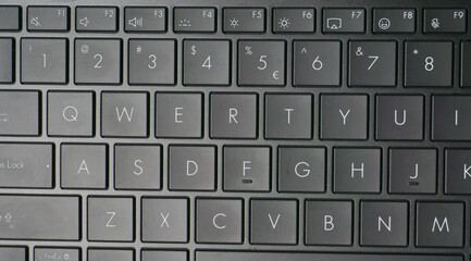Close-up image of a black QWERTY keyboard, highlighting the number row and letter keys with clear white symbols on matte keycaps.