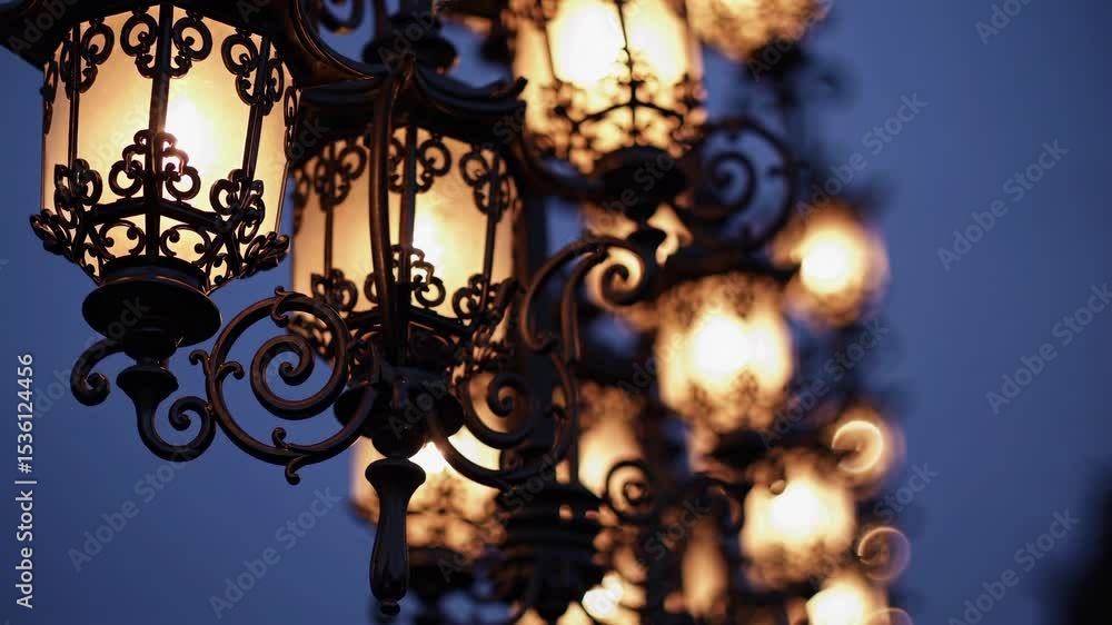 Aufkleber ornate lanterns glow warmly in a row against a twilight sky, captured from a low angle, creating a v