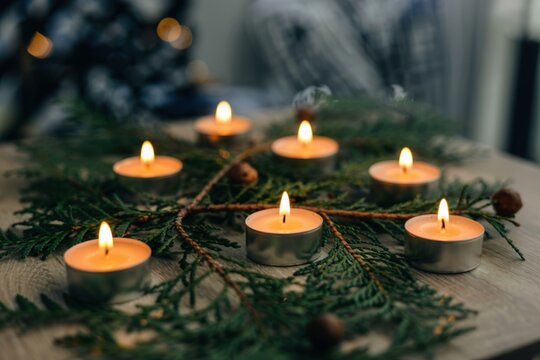 Close up tealight candles in evergreen pine branches concept photo