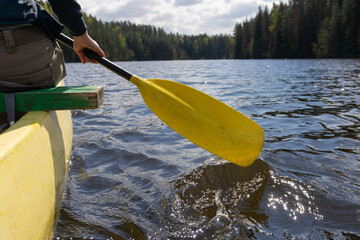 Canoeing adventure on a calm forest lake in Estonia with sunlight and scenic nature