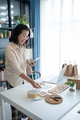Mature asian woman business E-commerce entrepreneurship owner take pictures of products Cardboard...