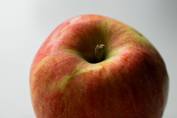 A close-up image of a fresh red and green apple with a smooth surface on a white background.