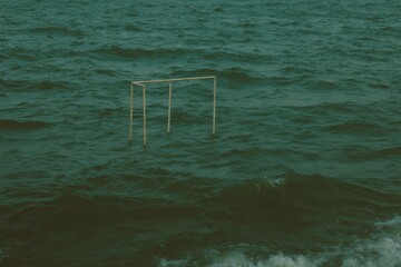 Climate Change Impact Partially Submerged Playground Swing Set in Rising Ocean Waters with Moody Forest Green Tones for Environmental Awareness