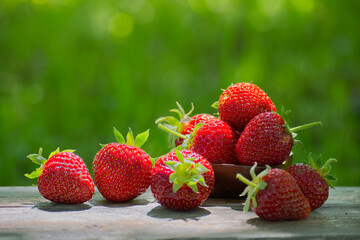 Fresh strawberries resting on wooden table with green background