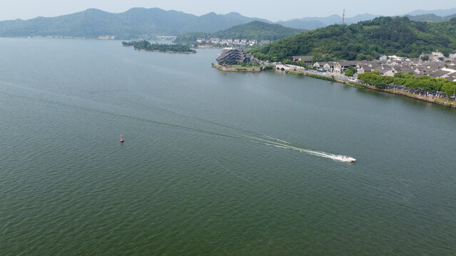 Aerial and ground views of Dongqian Lake and Art Center in Ningbo, China. Scenic lake, yachts, marina and iconic modern architecture surrounded by forested hills.