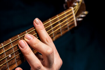 the hand clamps a chord on the guitar. playing a musical instrument. music education. lifestyle, A...