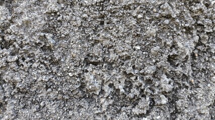 Old concrete surface with rough grunge texture and natural stone wall pattern, suitable for vintage backgrounds, architecture themes, or realistic aged visual elements in design.
