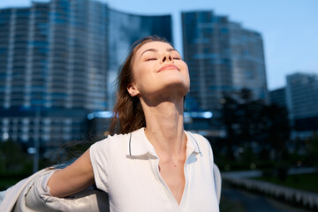 Fototapeta premium Confident businesswoman enjoying the moment in an urban setting, wearing a stylish outfit with a radiant smile, capturing empowerment and success.