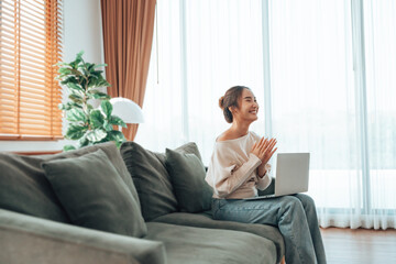 Funny euphoric young asian woman celebrating winning or getting ecommerce shopping offer on computer laptop. Excited happy girl winner looking at notebook celebrating success