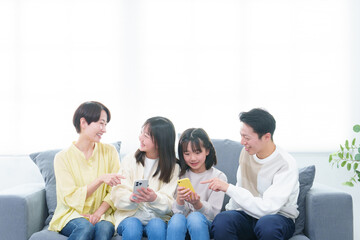 リビングでスマートフォンを使う親子