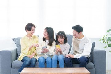 リビングでスマートフォンを使う親子