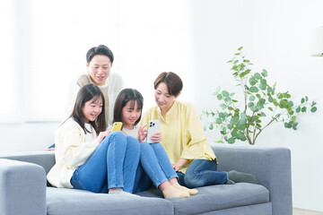 リビングでスマートフォンを使う親子