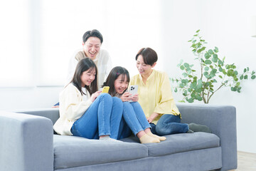 リビングでスマートフォンを使う親子