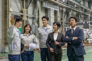 訪問者に工場を案内する作業員