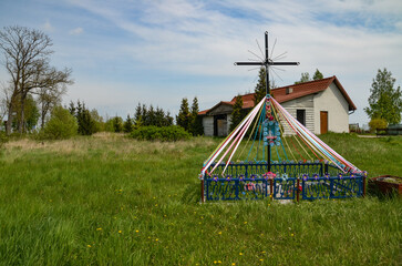 a cross in the Mazurian village decorated with ribbons