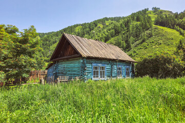 blue log rustic house on a green lawn