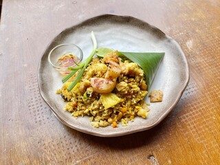 Pineapple fried rice with scallops and prawns, served in fresh banana leaf cone on dishes. Famous Thai food