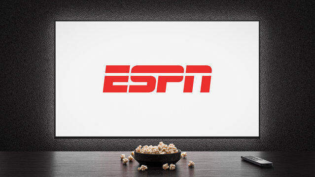 A TV showing the logo splash screen of ESPN, with a bowl of popcorn and TV remote in the foreground