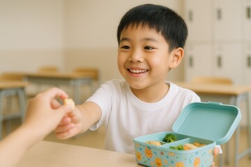 Smiling Asian boy sharing lunchbox snack in classroom setting