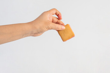 Square crispy snack in hand on white background