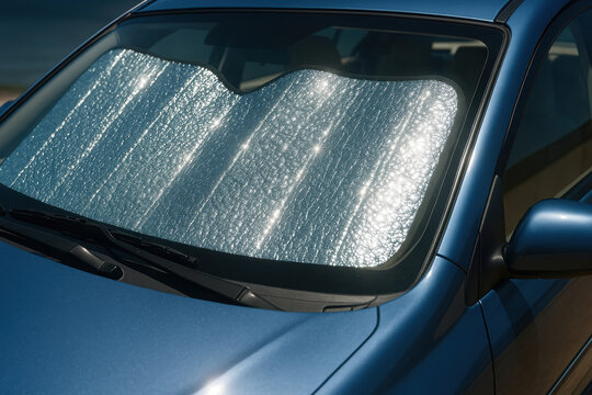 Fototapeta Reflective sunshade protecting car interior from sunlight and heat through front windshield on a bright summer day