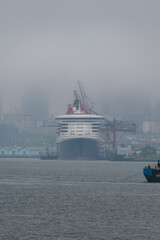 Luxury ocean liner cruiseship cruise ship Queen Mary docked at terminal in Brooklyn on grey rainy...