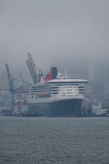 Luxury ocean liner cruiseship cruise ship Queen Mary docked at terminal in Brooklyn on grey rainy...