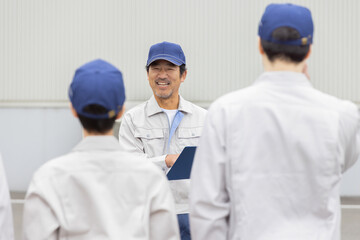  屋外でミーティングする作業員グループ