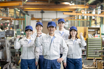 工場の中に立つ作業員グループ