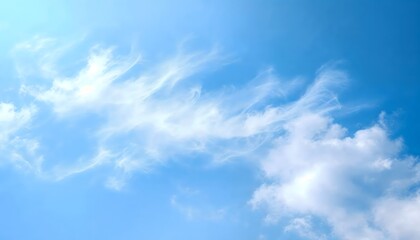 Fototapeta premium Wispy clouds drift across a clear blue sky on a sunny day