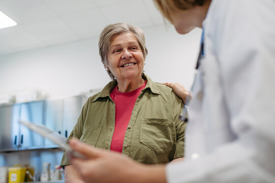 Geriatrician talking about test results with senior patient during check-up.