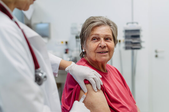 Elderly patient being vaccinated by doctor.