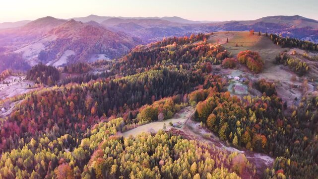 Ukraine, drone, flight in the Carpathians early autumn morning at sunrise near the city of Kosiv. Bright forests and frost of the night frost