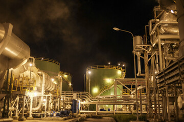 Industrial facility illuminated at night with tanks