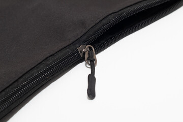 black fabric bag featuring a sleek, rubberized zipper with a metallic pull tab, set against white background.