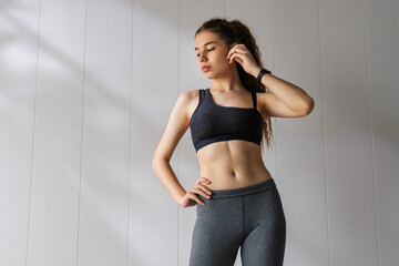 Woman in fashionable sportswear is doing exercise.