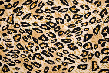 Dark black yellow soft leopard spot pattern fabric background. Closeup. Top down view.