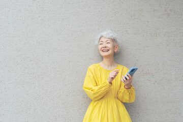 笑顔でスマホを使うシニア女性