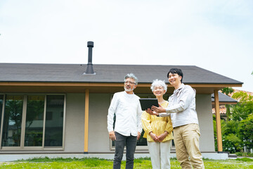 住宅の前で説明する男性作業員とシニアカップル