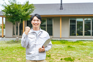 住宅の前でガッツポーズする男性作業員