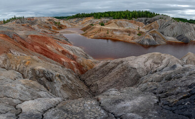 Ural Mars. An extraordinarily beautiful summer landscape with red lakes, colorful slopes and forest. A picturesque mountain range. Natural landscape, impressive sky. Nature of the Urals.