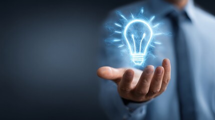 A businessman holds a glowing light bulb, symbolizing innovative ideas and creativity.