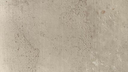 Rough textured beige wall with cracked areas and weathered paint details, offering a natural distressed look for abstract backdrops and creative background usage.
