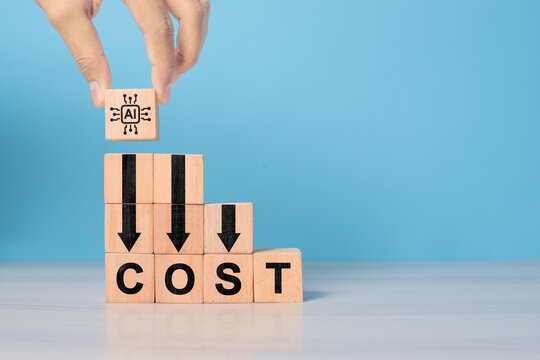 Lean or Cost reduction by Machine learning. AI or Artifice intelligence to optimize manufacturing. Decreasing expense to maximize profits. Hand put wooden cube with AI icon and cost down green arrows