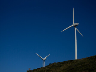 Wind Turbines on a Hill Under Clear Blue Sky