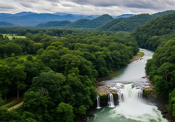 Fototapeta premium Lush Green Forests Surround A Powerful Waterfall Cascading Over Rocks Into A River Set Against A Backdrop Of Rolling Blue Hills And Dramatic Skies