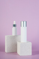 Plastic white tube for cream or lotion. Skin care or sunscreen cosmetic with stylish props on purple background.