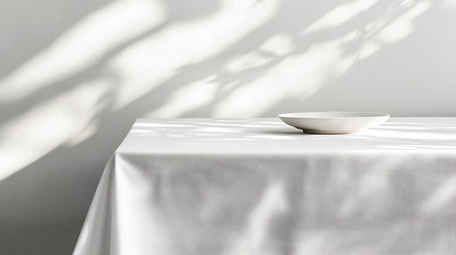 A table covered with a white tablecloth with empty plates on it