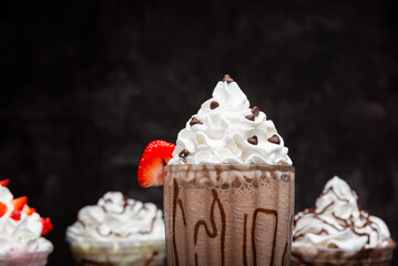Chocolate milkshake served in a tall glass on a dark background. Isolated drink
